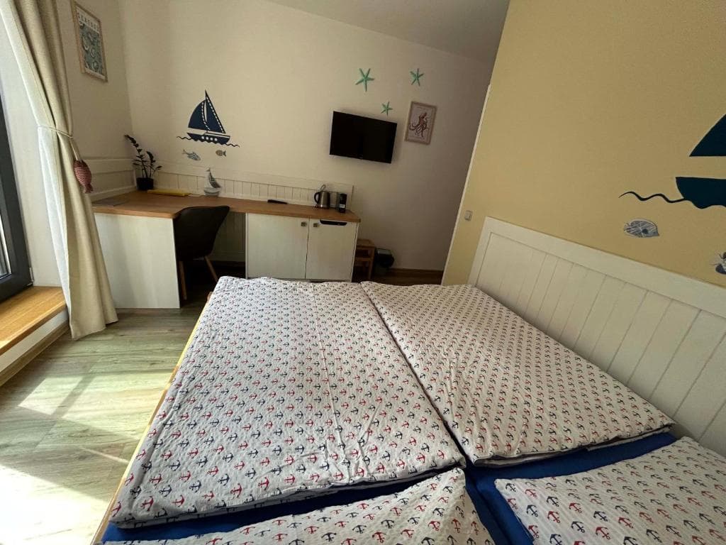Balkon dvoulůžkového pokoje s posezením mezi stromy