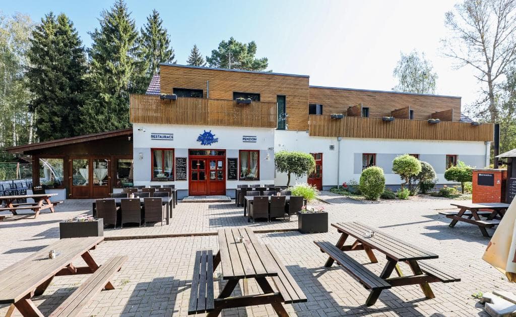 Zahrádka restaurace Labská Marína s piknikovými stoly, obklopená stromy