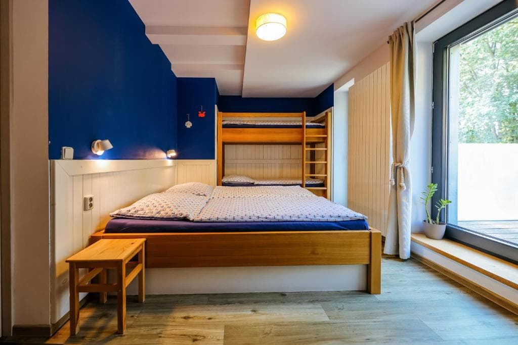Rodinný pokoj s tmavě modrou stěnou a zabudovanou palandou