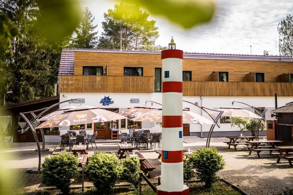 Terasa restaurace s pruhovaným majákem a slunečníky